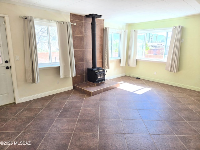 290 N Paseo De Los Conquistadores, Green Valley, AZ 85614 - unfurnished living room featuring a wood stove, dark tile patterned floors, and baseboards
