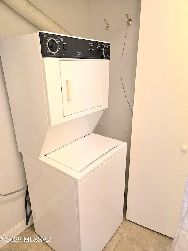 290 N Paseo De Los Conquistadores, Green Valley, AZ 85614 - laundry area featuring stacked washer and clothes dryer, light tile patterned floors, and baseboards