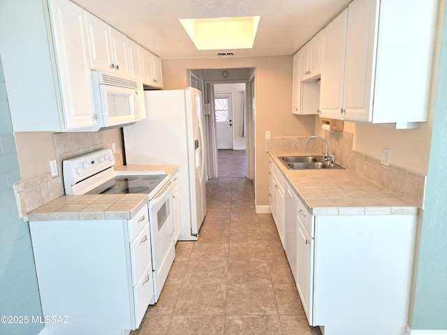 290 N Paseo De Los Conquistadores, Green Valley, AZ 85614 - kitchen with a sink, white appliances, white cabinets, and light tile patterned flooring