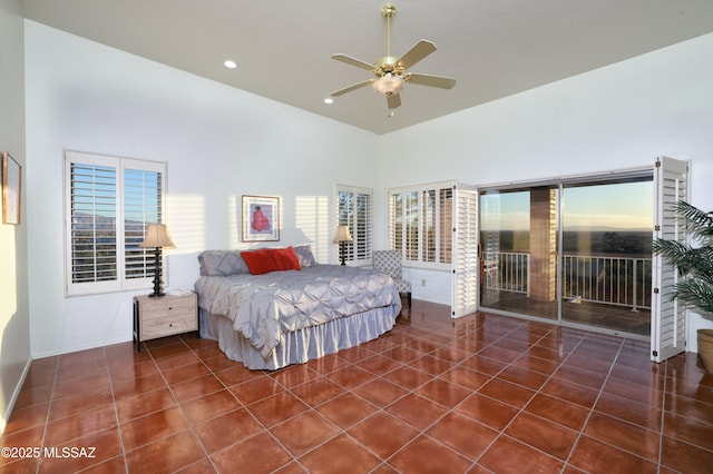 tiled bedroom featuring a ceiling fan, a high ceiling, multiple windows, and access to exterior