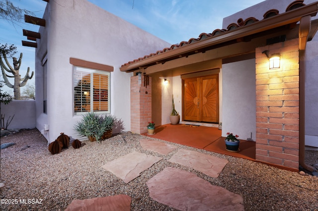 property entrance with stucco siding