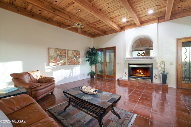tiled living room with beam ceiling, a warm lit fireplace, recessed lighting, wooden ceiling, and a ceiling fan