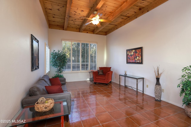 living area with ceiling fan, vaulted ceiling with beams, tile patterned flooring, wood ceiling, and baseboards