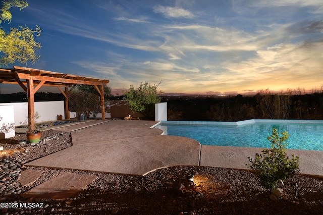 pool at dusk featuring an infinity pool, a patio, and a pergola