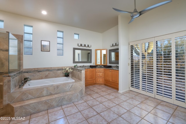 full bathroom featuring double vanity, a ceiling fan, a sink, tile patterned flooring, and a bath