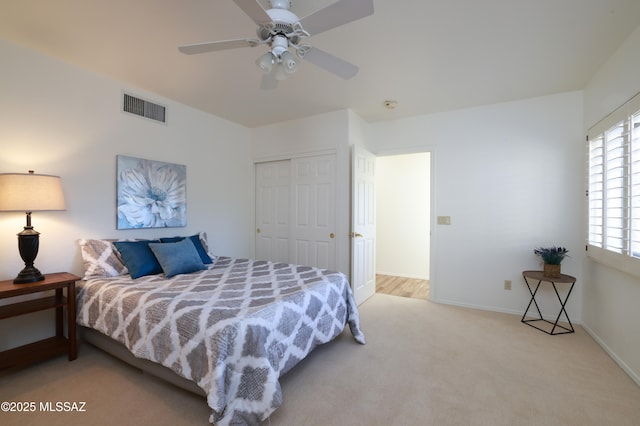 bedroom with baseboards, visible vents, ceiling fan, carpet flooring, and a closet