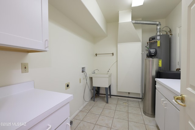 washroom with water heater, washer hookup, light tile patterned flooring, and cabinet space