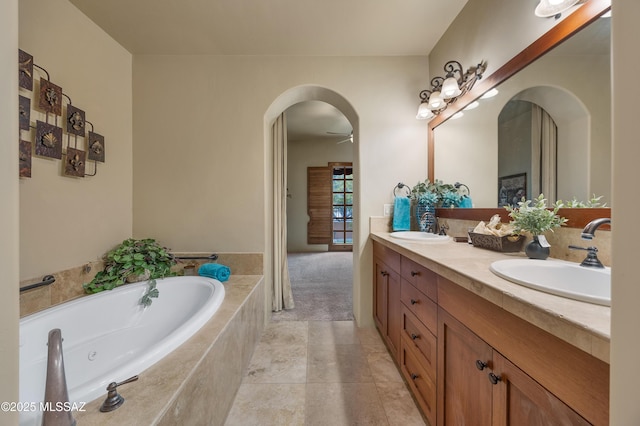 bathroom featuring vanity, tiled bath, and tile patterned flooring