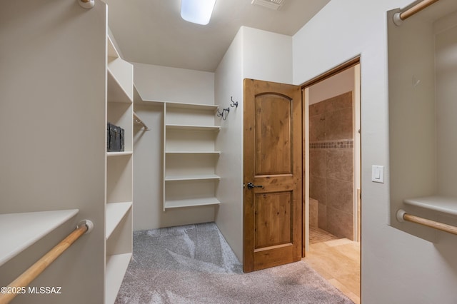 walk in closet featuring light colored carpet