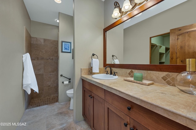 bathroom with vanity, tasteful backsplash, toilet, and walk in shower