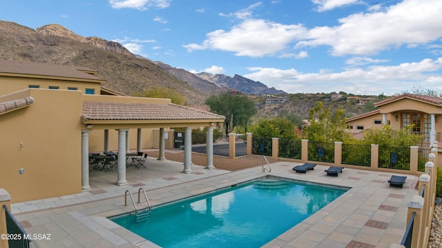 view of pool with a patio and a mountain view