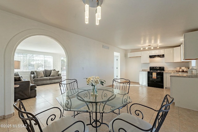 tiled dining room featuring track lighting