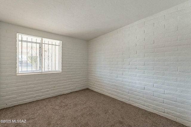 empty room with brick wall and carpet floors