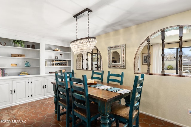 tiled dining room featuring built in shelves and a notable chandelier