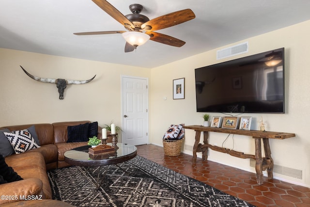 living room featuring dark tile patterned flooring and ceiling fan