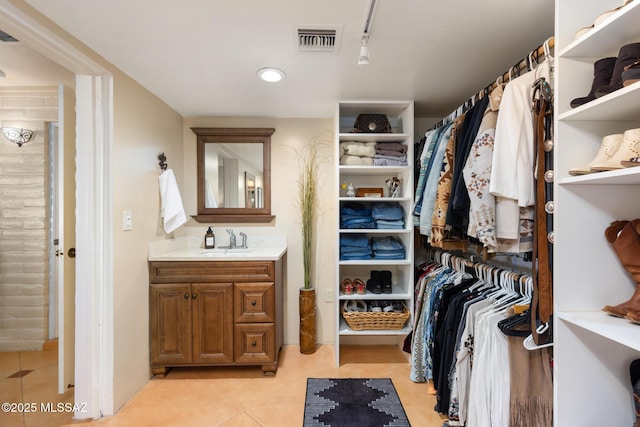 spacious closet featuring sink and light tile patterned floors