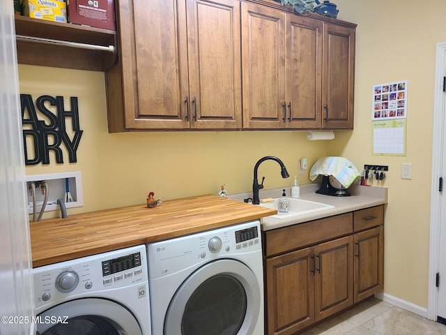 laundry room with sink, cabinets, washing machine and clothes dryer, and light tile patterned flooring