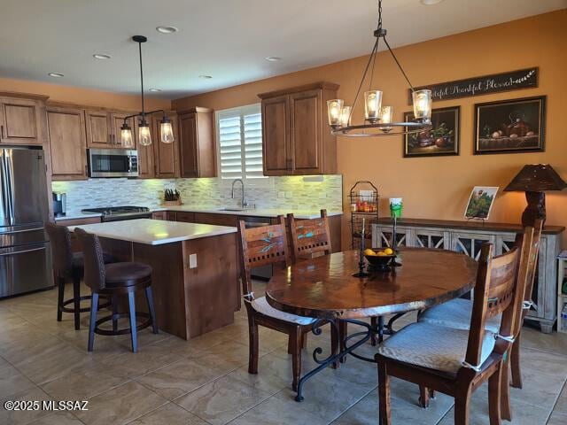 kitchen with sink, decorative light fixtures, a center island, and appliances with stainless steel finishes