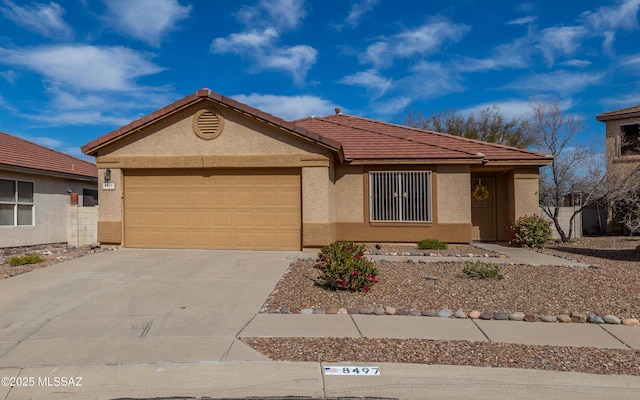 single story home featuring a garage, driveway, a tile roof, and stucco siding