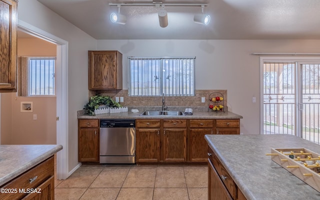 8497 E Hodgman Pl, Tucson, AZ 85747 - kitchen featuring dishwasher, a sink, decorative backsplash, and plenty of natural light