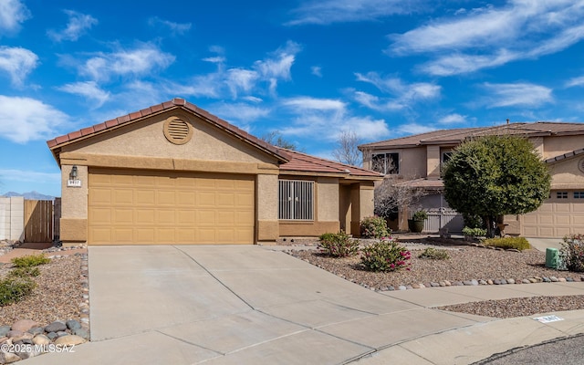 8497 E Hodgman Pl, Tucson, AZ 85747 - single story home with stucco siding, driveway, an attached garage, and a tile roof
