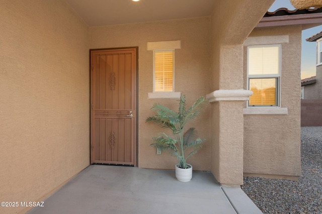 doorway to property featuring stucco siding