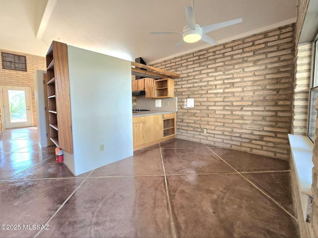 kitchen with ceiling fan, brick wall, and light brown cabinets