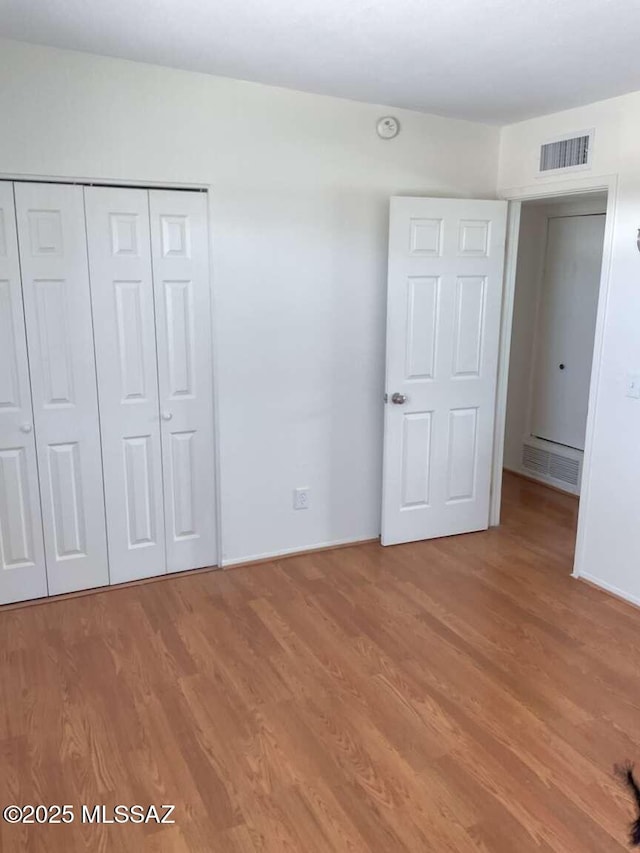 unfurnished bedroom with light hardwood / wood-style floors and a closet