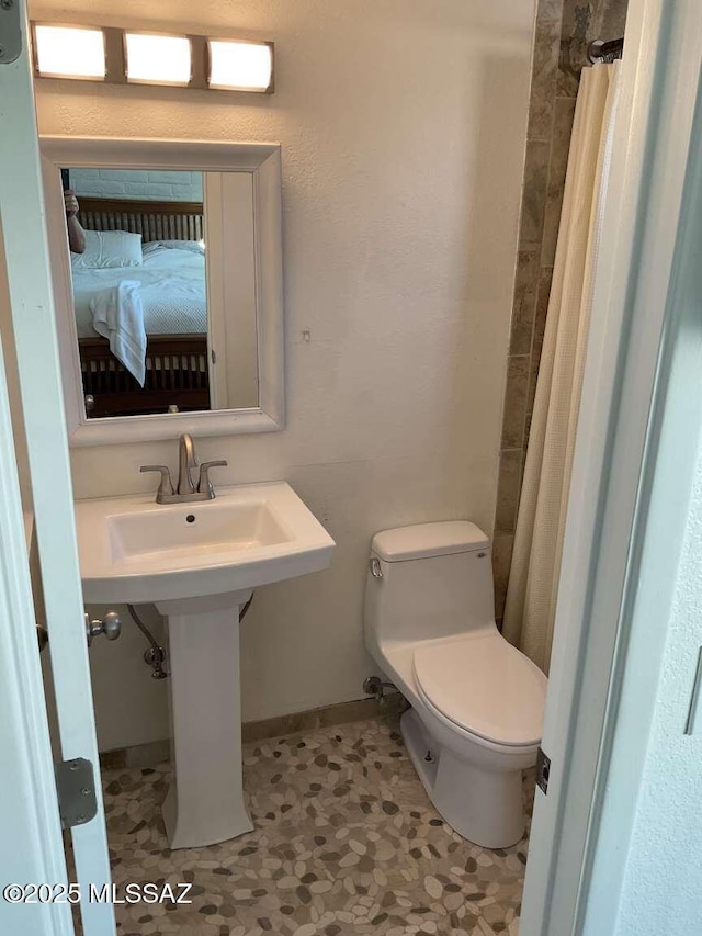 bathroom with toilet and a shower with shower curtain