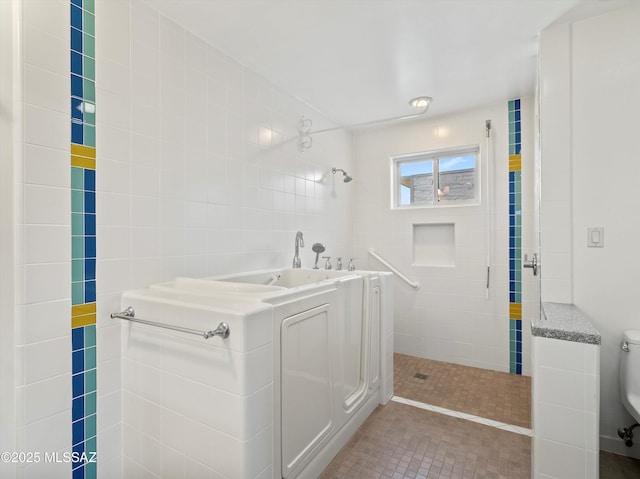 full bathroom with a tile shower and toilet