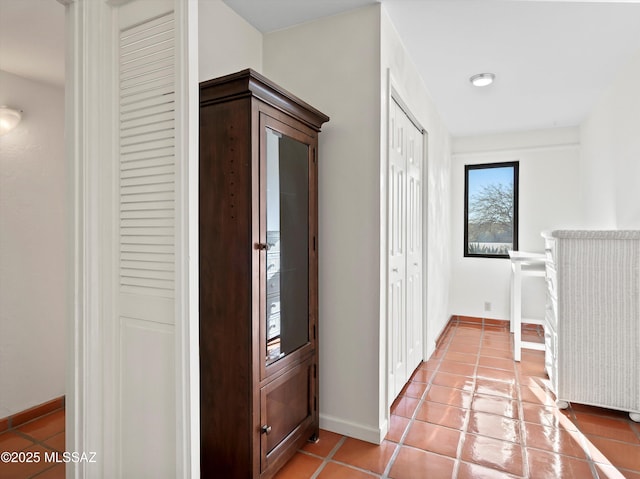 hallway featuring baseboards and light tile patterned floors