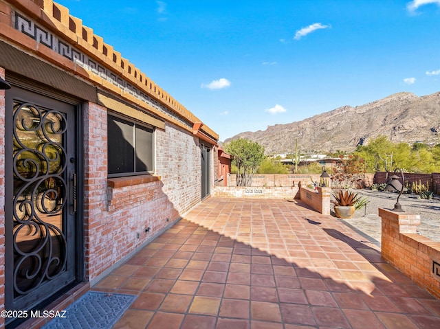 view of patio featuring fence and a mountain view