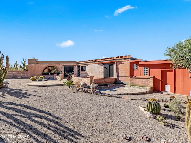 view of front of property with a patio and brick siding