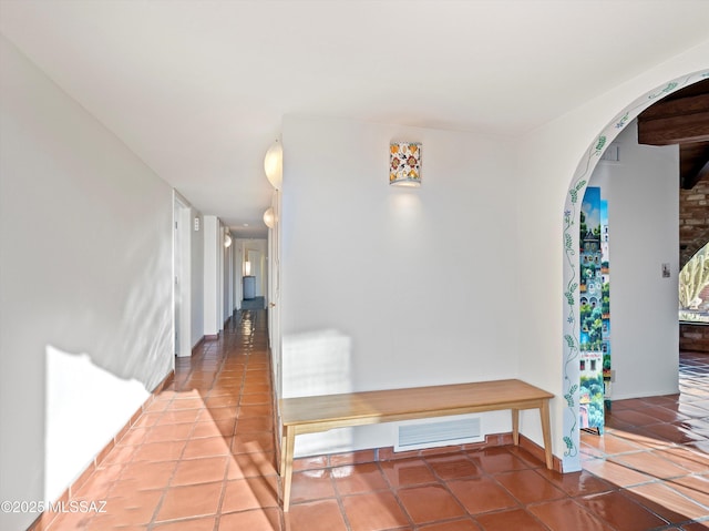 corridor with arched walkways, tile patterned flooring, and visible vents