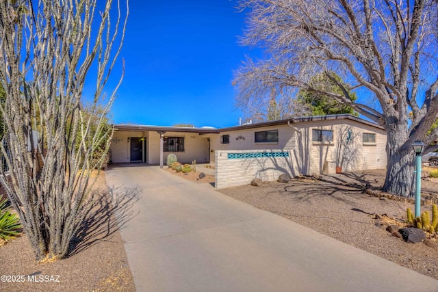 single story home featuring concrete driveway and brick siding