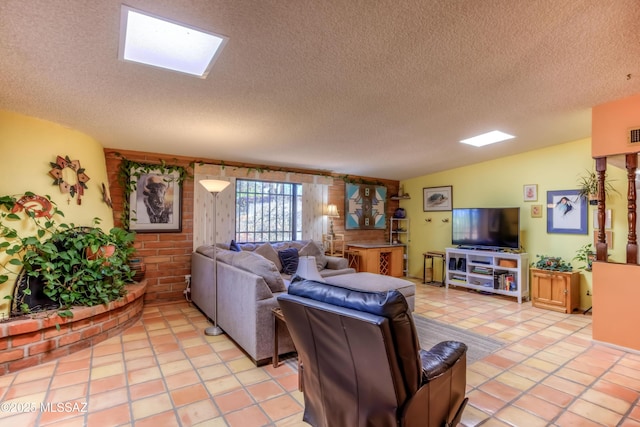 living area with light tile patterned floors, a textured ceiling, and a skylight