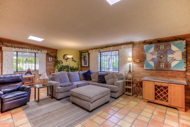 living room featuring a textured ceiling, light tile patterned floors, and a healthy amount of sunlight