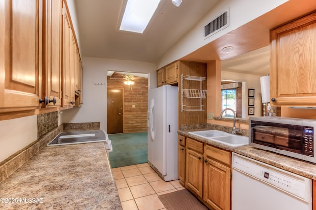 kitchen featuring white appliances, visible vents, light countertops, a sink, and light tile patterned flooring