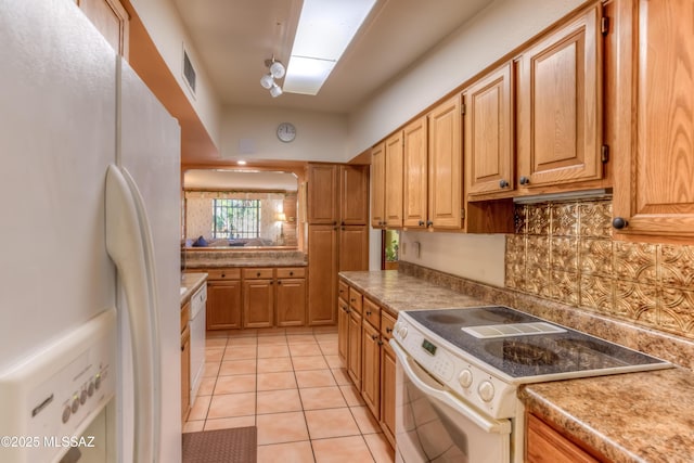 kitchen featuring white appliances, light tile patterned floors, visible vents, decorative backsplash, and light countertops