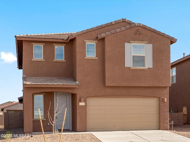 view of front of house with an attached garage, fence, driveway, and stucco siding