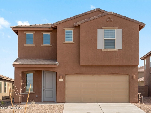 view of front of property with stucco siding, an attached garage, and concrete driveway