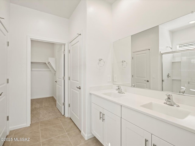 full bath featuring tile patterned flooring, a shower stall, double vanity, and a sink