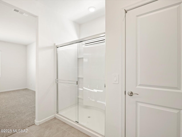 bathroom featuring tile patterned floors, visible vents, a shower stall, and baseboards