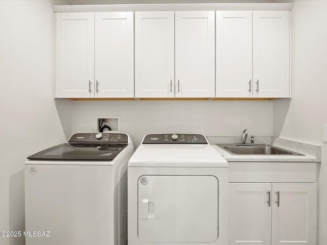 laundry area featuring a sink, cabinet space, and washer and clothes dryer