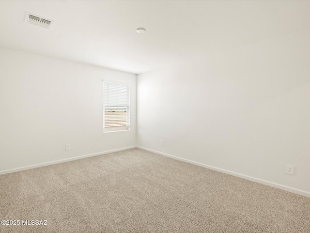 spare room with visible vents, carpet floors, and baseboards