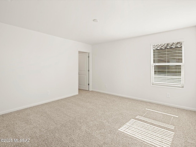 carpeted spare room with baseboards