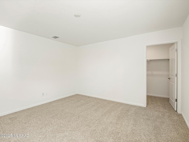 unfurnished bedroom with a spacious closet, baseboards, a closet, and light carpet