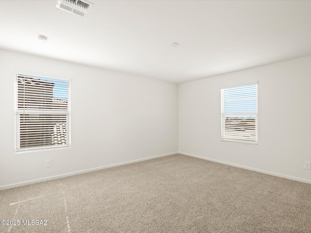 unfurnished room featuring visible vents, baseboards, and carpet