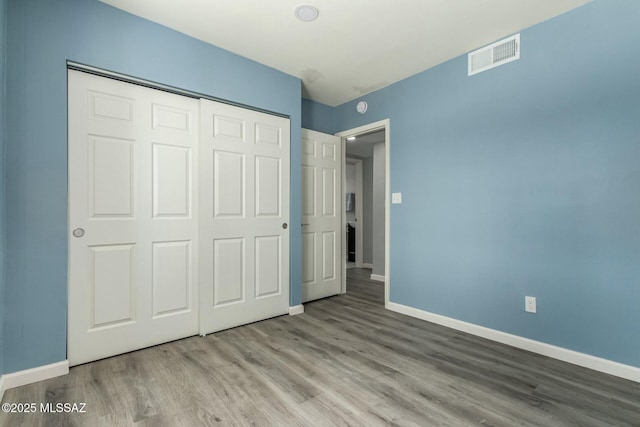 unfurnished bedroom featuring light hardwood / wood-style floors and a closet