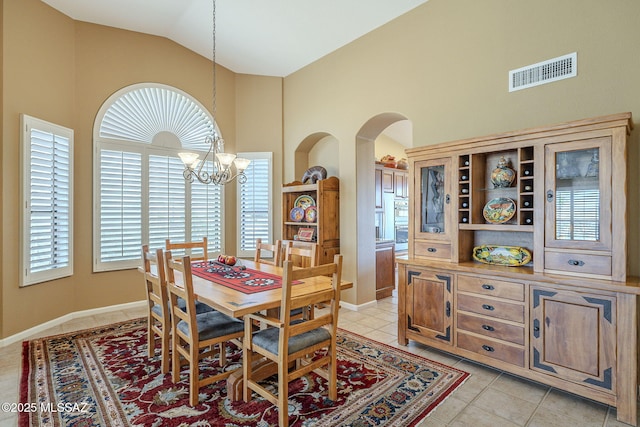 dining room with a chandelier, light tile patterned flooring, arched walkways, and visible vents